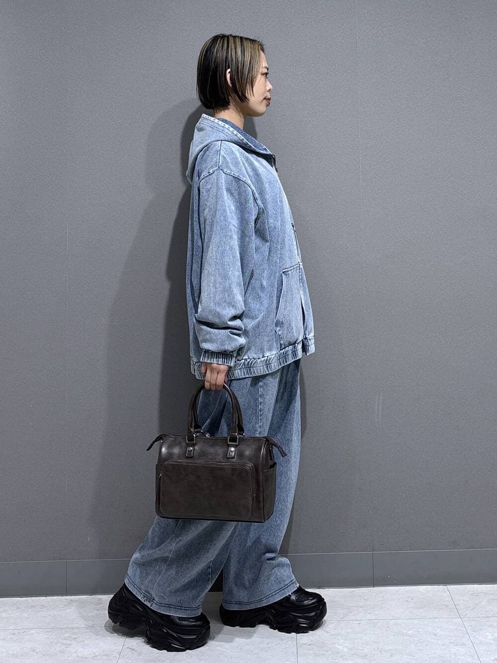 ブラック系のスニーカー、グレー系のショルダーバッグ、イエロー系のTシャツ/カットソーを着用したレディースの春コーディネートの4枚目の写真