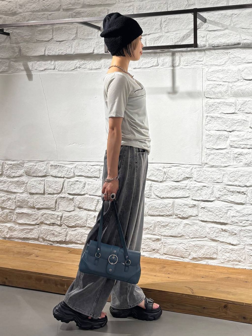 ブラック系のデニムパンツ、グレー系のサンダル、ベージュ系のTシャツ/カットソーを着用したレディースの夏コーディネートの5枚目の写真