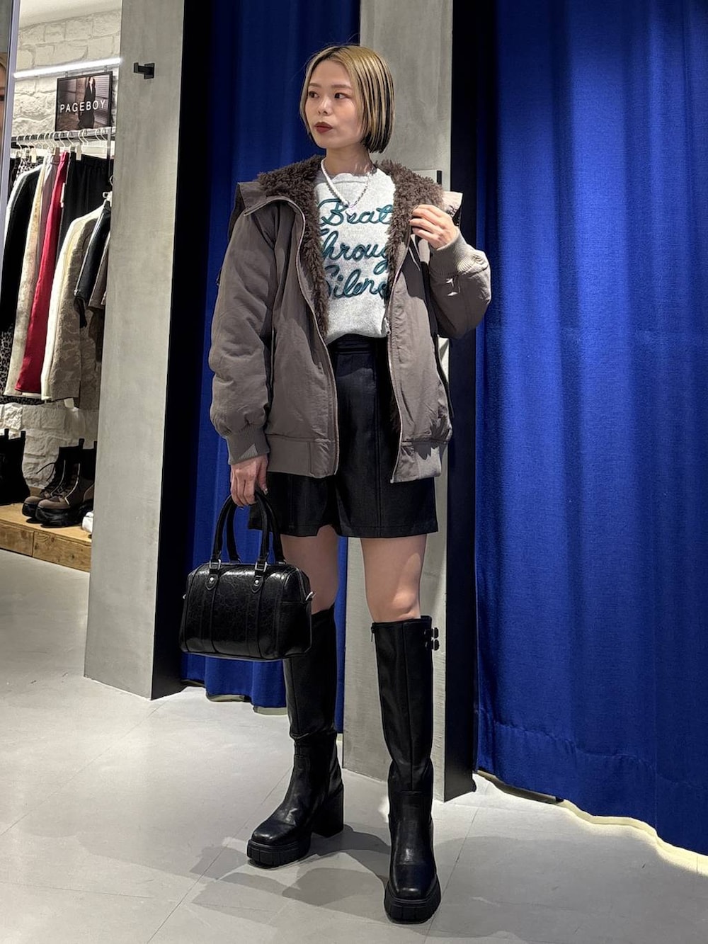 ブラック系のブーツ、ブラウン系のブルゾン、ブラック系のその他パンツを着用したレディースの冬コーディネートの4枚目の写真