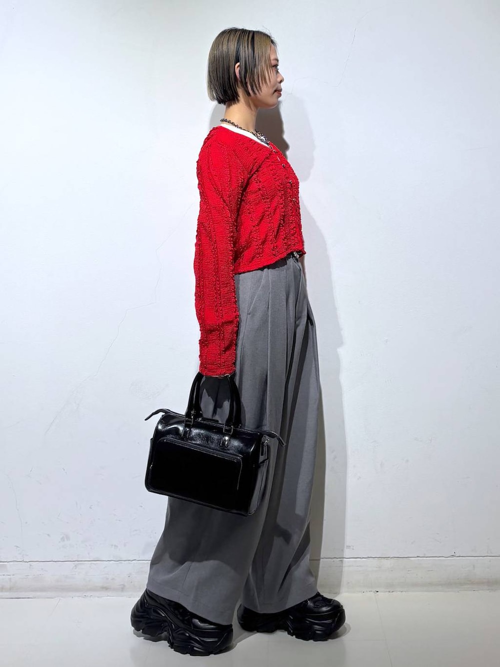 ブラック系のショルダーバッグ、ホワイト系のTシャツ/カットソー、レッド系のTシャツ/カットソーを着用したレディースの春コーディネートの4枚目の写真