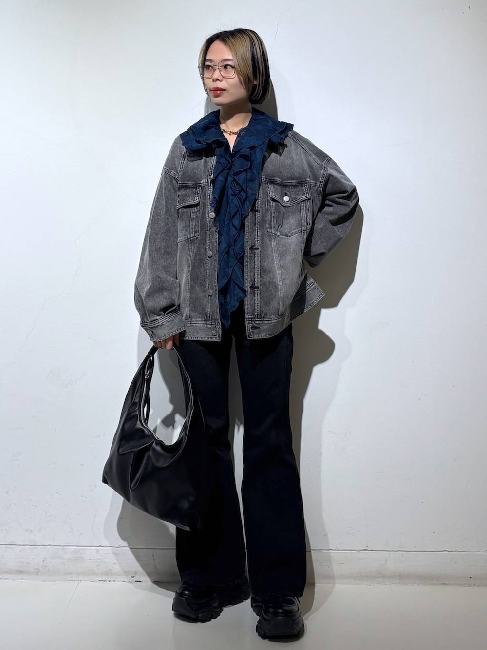 ブラック系のスニーカー、ブラック系のデニムパンツ、ブラック系のブルゾンを着用したレディースの春コーディネートの2枚目の写真