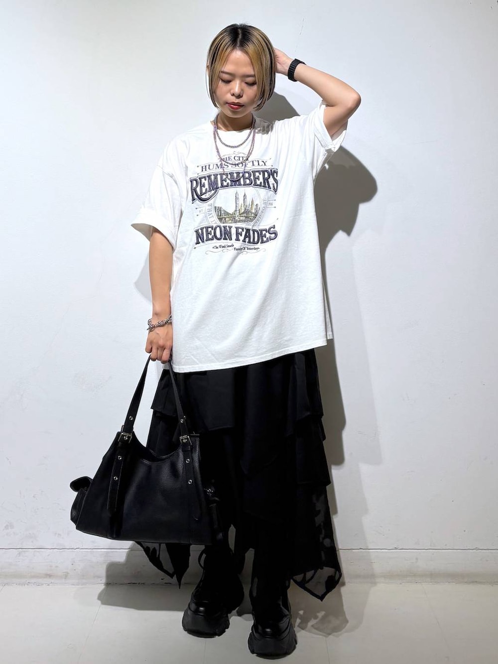 ブラック系のブーツ、ホワイト系のTシャツ/カットソー、ブラック系のハンドバッグを着用したレディースの夏コーディネートの2枚目の写真