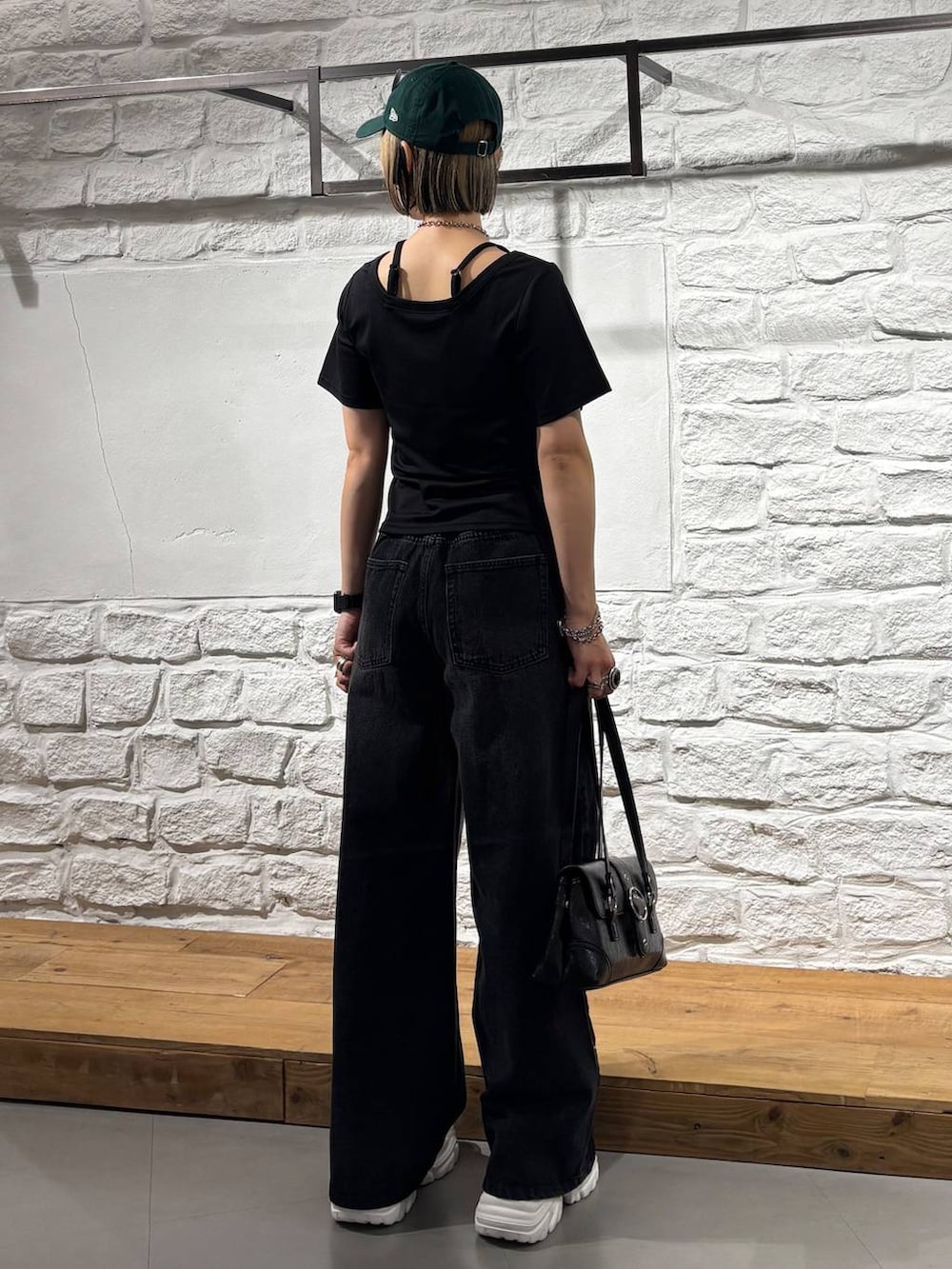 ブラック系のデニムパンツ、ブラック系のTシャツ/カットソー、ホワイト系のスニーカーを着用したレディースの夏コーディネートの6枚目の写真