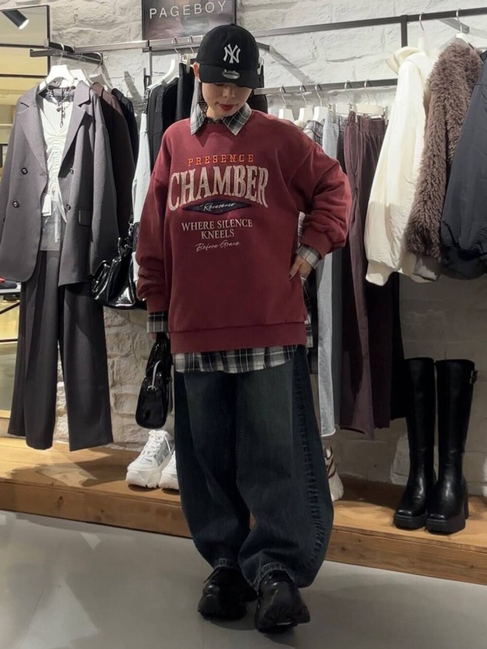 ブラック系のブーツ、レッド系のスウェット、ブラック系のTシャツ/カットソーを着用したレディースの秋コーディネートの3枚目の写真