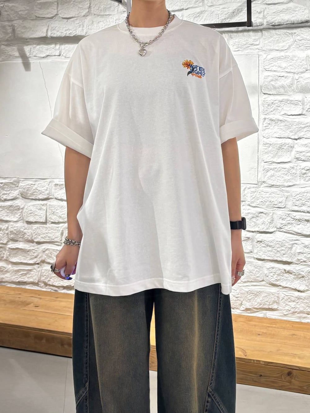 グリーン系のデニムパンツ、ブラック系のショルダーバッグ、グレー系のサンダルを着用したレディースの夏コーディネートの5枚目の写真
