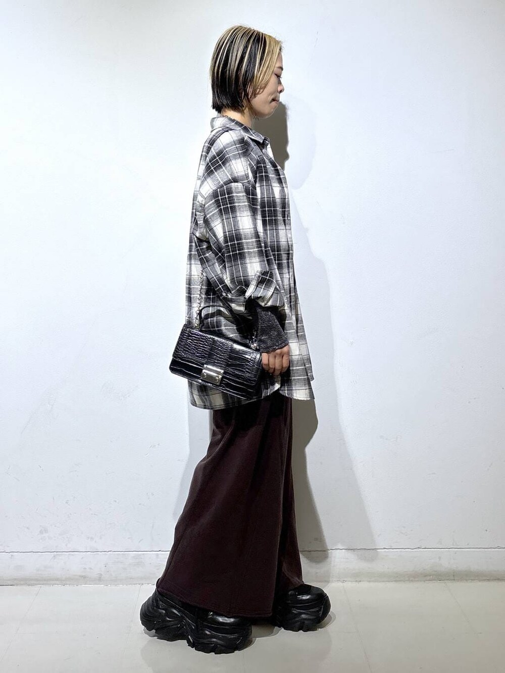 ブラック系のブーツ、シルバー系のTシャツ/カットソー、ブラウン系のスウェットパンツを着用したレディースの秋コーディネートの3枚目の写真