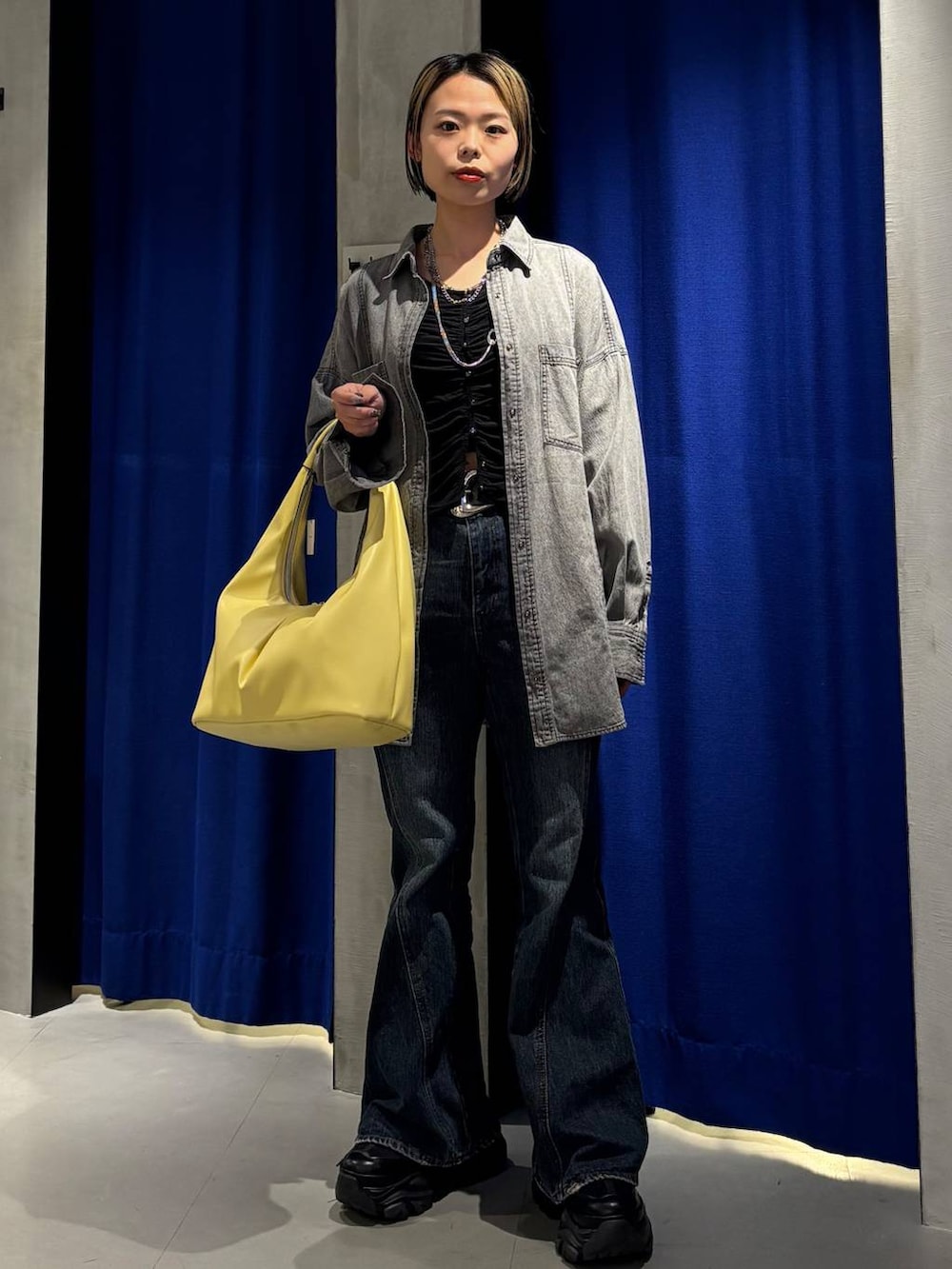 ブラック系のスニーカー、ブルー系のデニムパンツ、ブラック系のシャツ/ブラウスを着用したレディースの春コーディネートの2枚目の写真