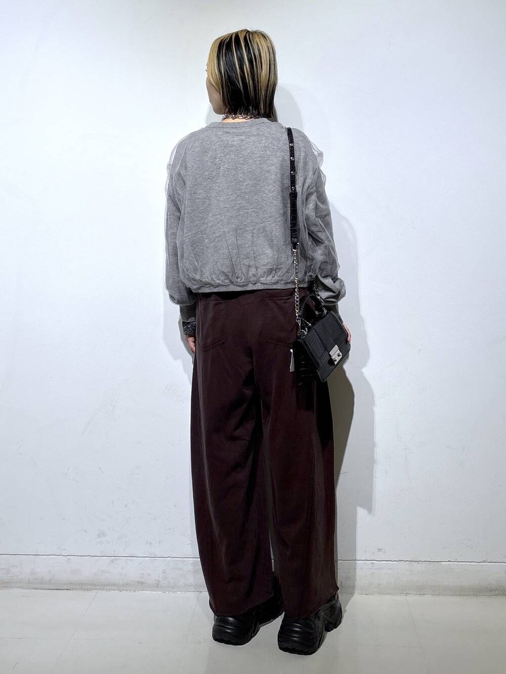 ブラック系のブーツ、シルバー系のTシャツ/カットソー、ブラウン系のスウェットパンツを着用したレディースの秋コーディネートの4枚目の写真