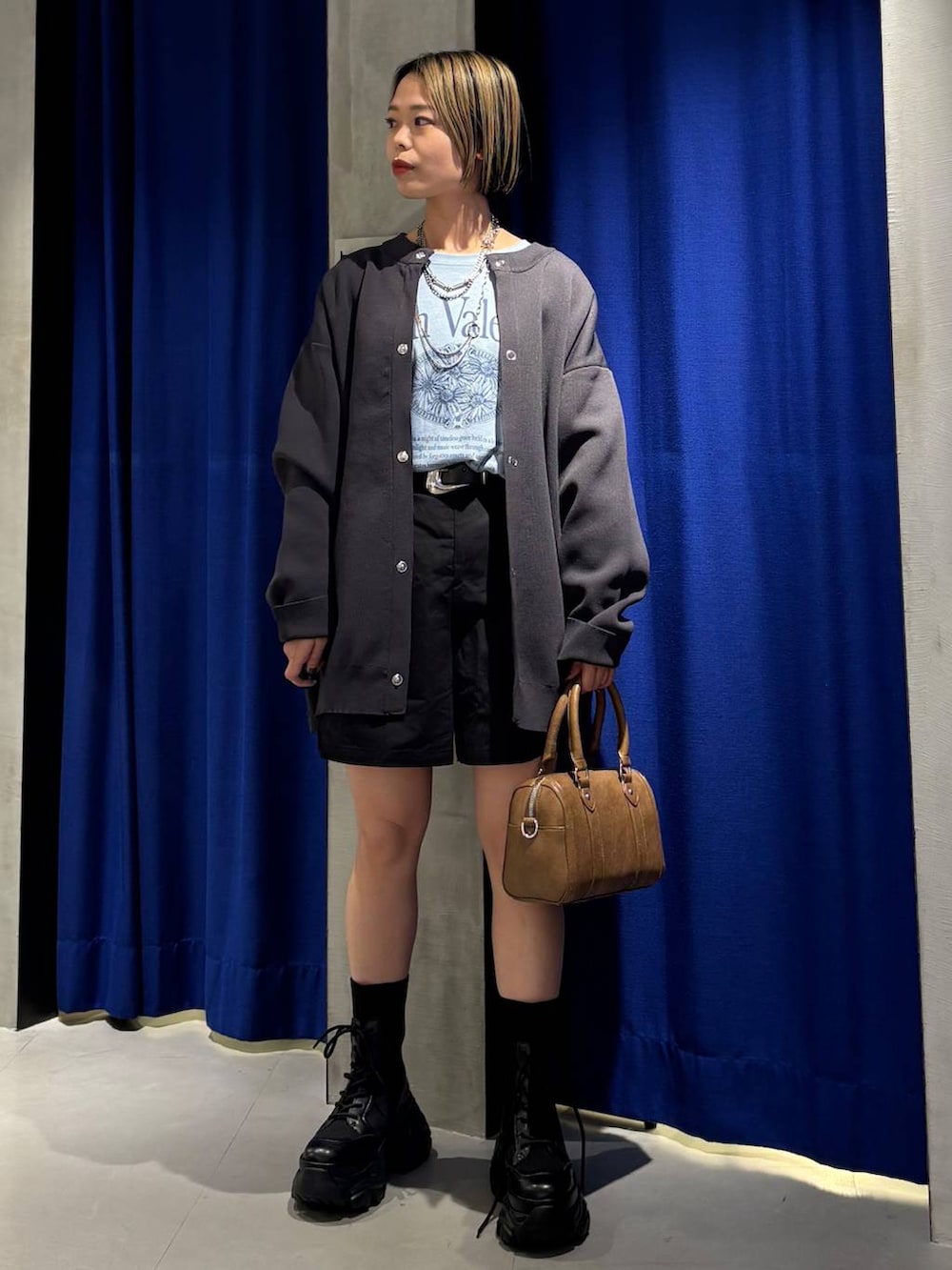 ブラック系のブーツ、ブラウン系のボストンバッグ、ブラック系のその他パンツを着用したレディースの春コーディネートの2枚目の写真