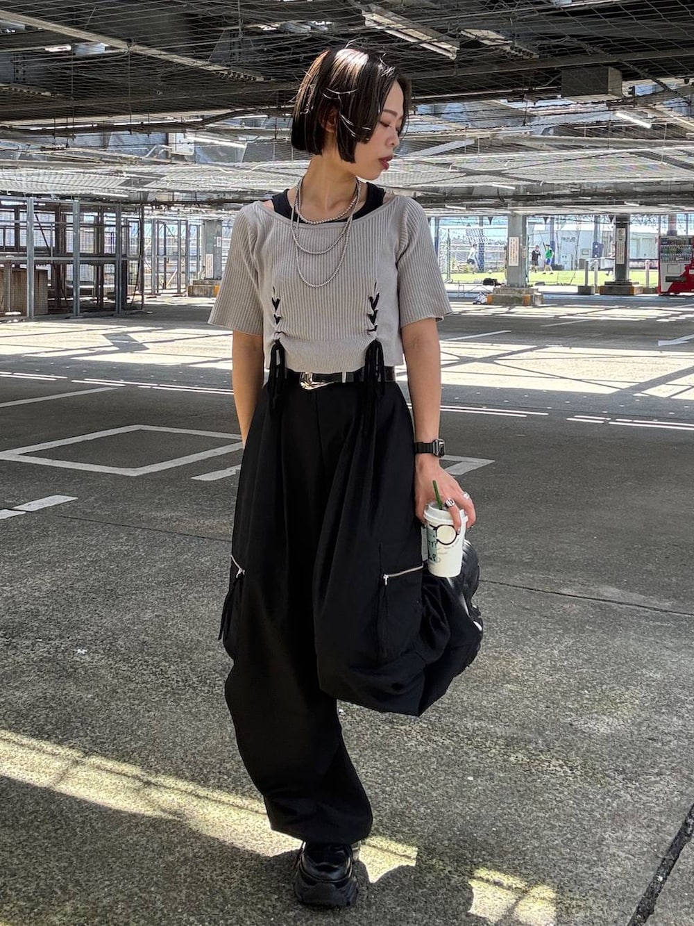 ブラック系のカーゴパンツ、グレー系のTシャツ/カットソー、ブラック系のスニーカーを着用したレディースの夏コーディネートの5枚目の写真