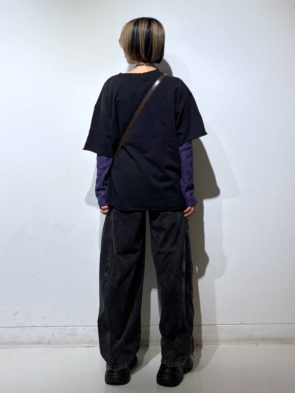 ブラック系のスニーカー、ブラウン系のショルダーバッグ、ブラック系のデニムパンツを着用したレディースの春コーディネートの5枚目の写真