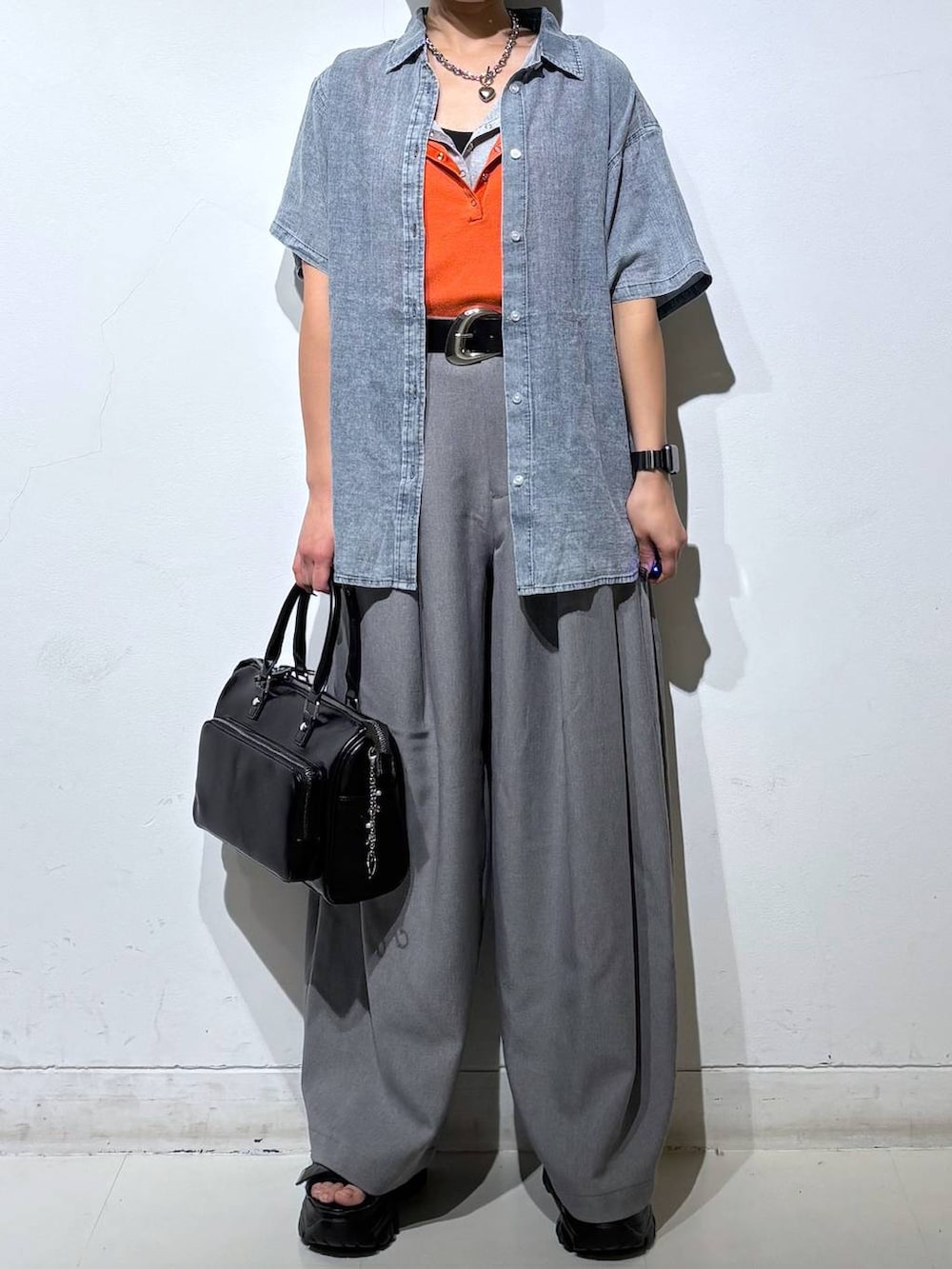 ブラック系のショルダーバッグ、グレー系のスラックス、グレー系のタンクトップを着用したレディースの春コーディネートの3枚目の写真