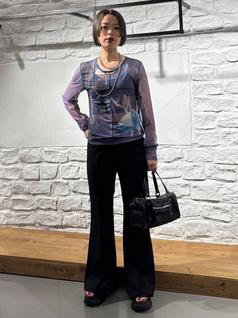 ブラック系のショルダーバッグ、ブラック系のスラックス、ブルー系のTシャツ/カットソーを着用したレディースの夏コーディネートの2枚目の写真