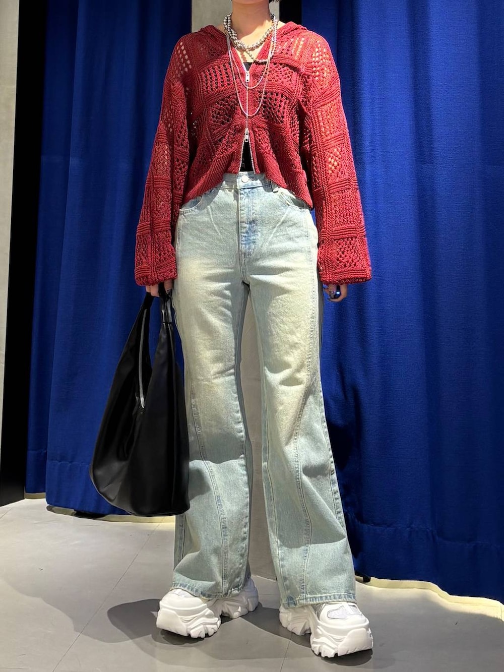 ホワイト系のスニーカー、ブラック系のキャミソール、ブルー系のデニムパンツを着用したレディースの春コーディネートの3枚目の写真