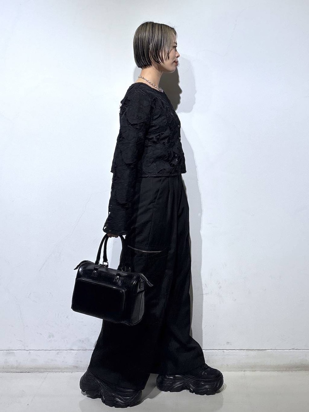 ブラック系のスニーカー、ブラック系のキャミソール、ブラック系のショルダーバッグを着用したレディースの春コーディネートの3枚目の写真