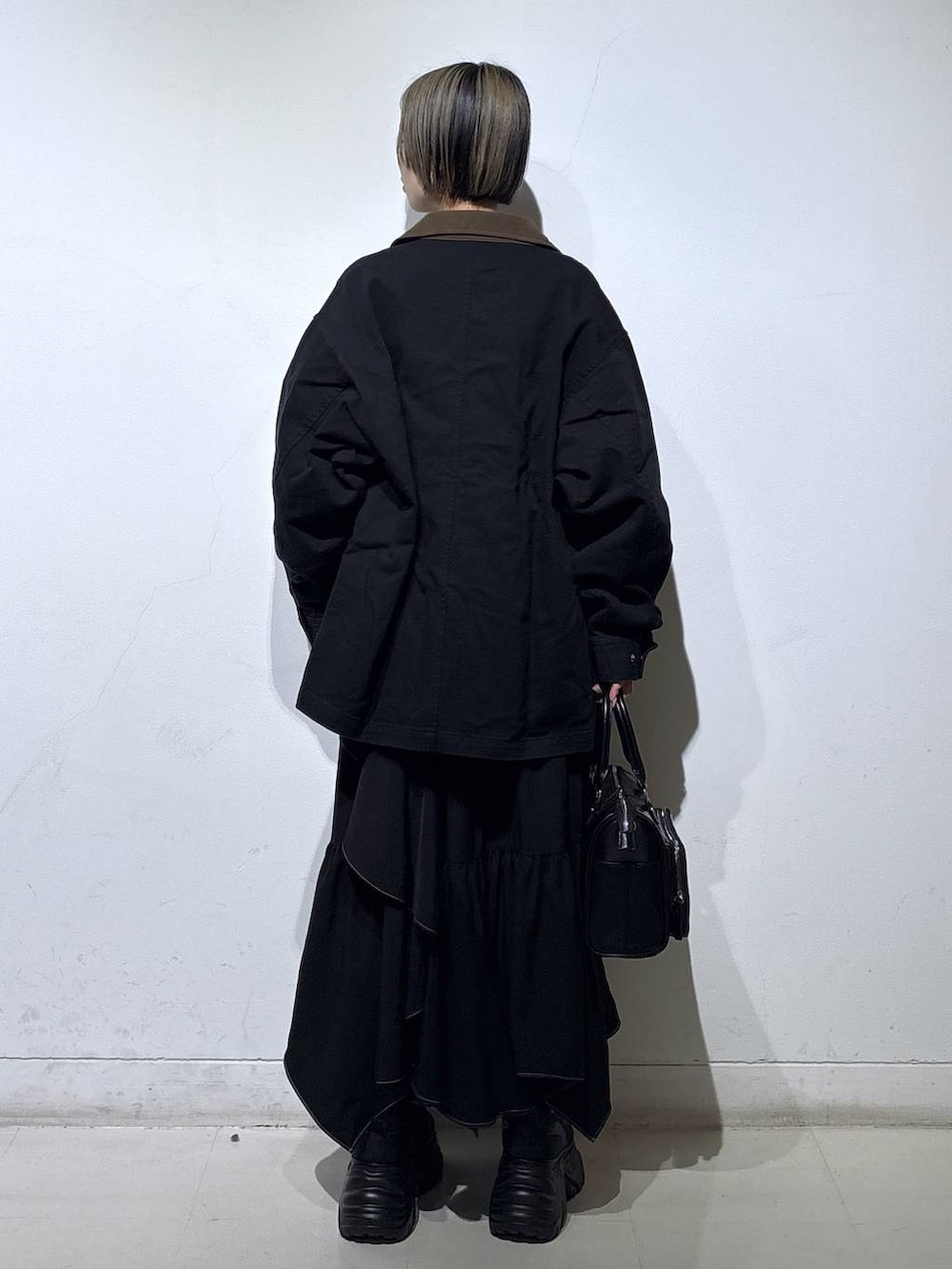 ブラック系のブーツ、グレー系のスウェット、ブラック系のスカートを着用したレディースの春コーディネートの4枚目の写真