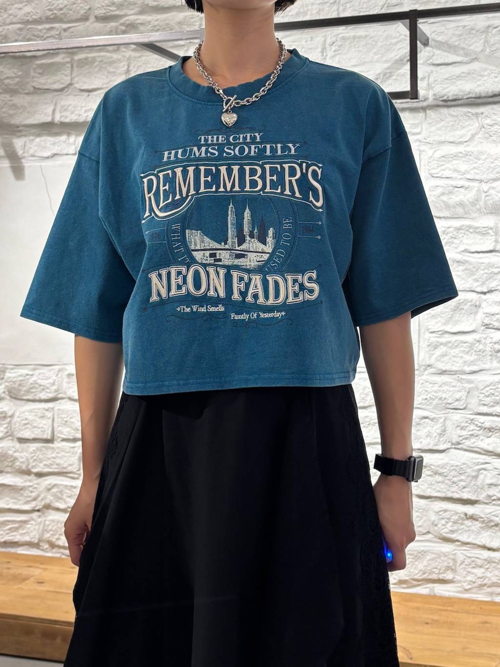 ブラック系のスカート、ブルー系のTシャツ/カットソー、ブラック系のショルダーバッグを着用したレディースの夏コーディネートの4枚目の写真