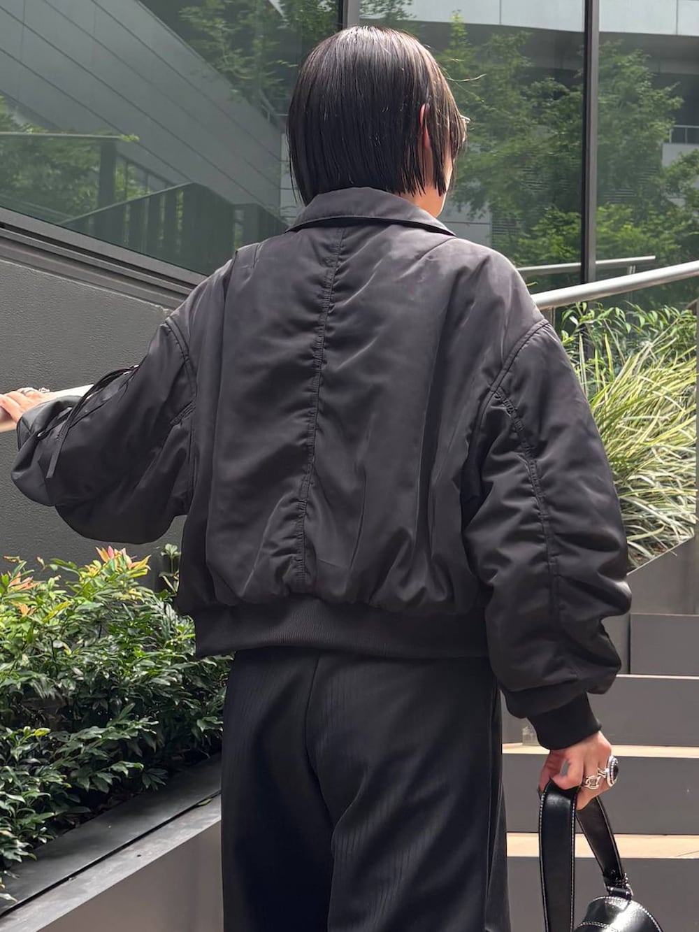 ブラック系のスニーカー、ブラック系のショルダーバッグ、ブラック系のキャミソールを着用したレディースの秋コーディネートの8枚目の写真