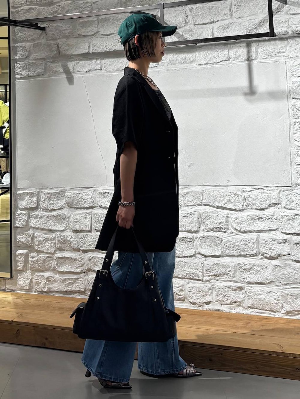ブルー系のデニムパンツ、ブラック系のタンクトップ、その他のサンダルを着用したレディースの春コーディネートの4枚目の写真