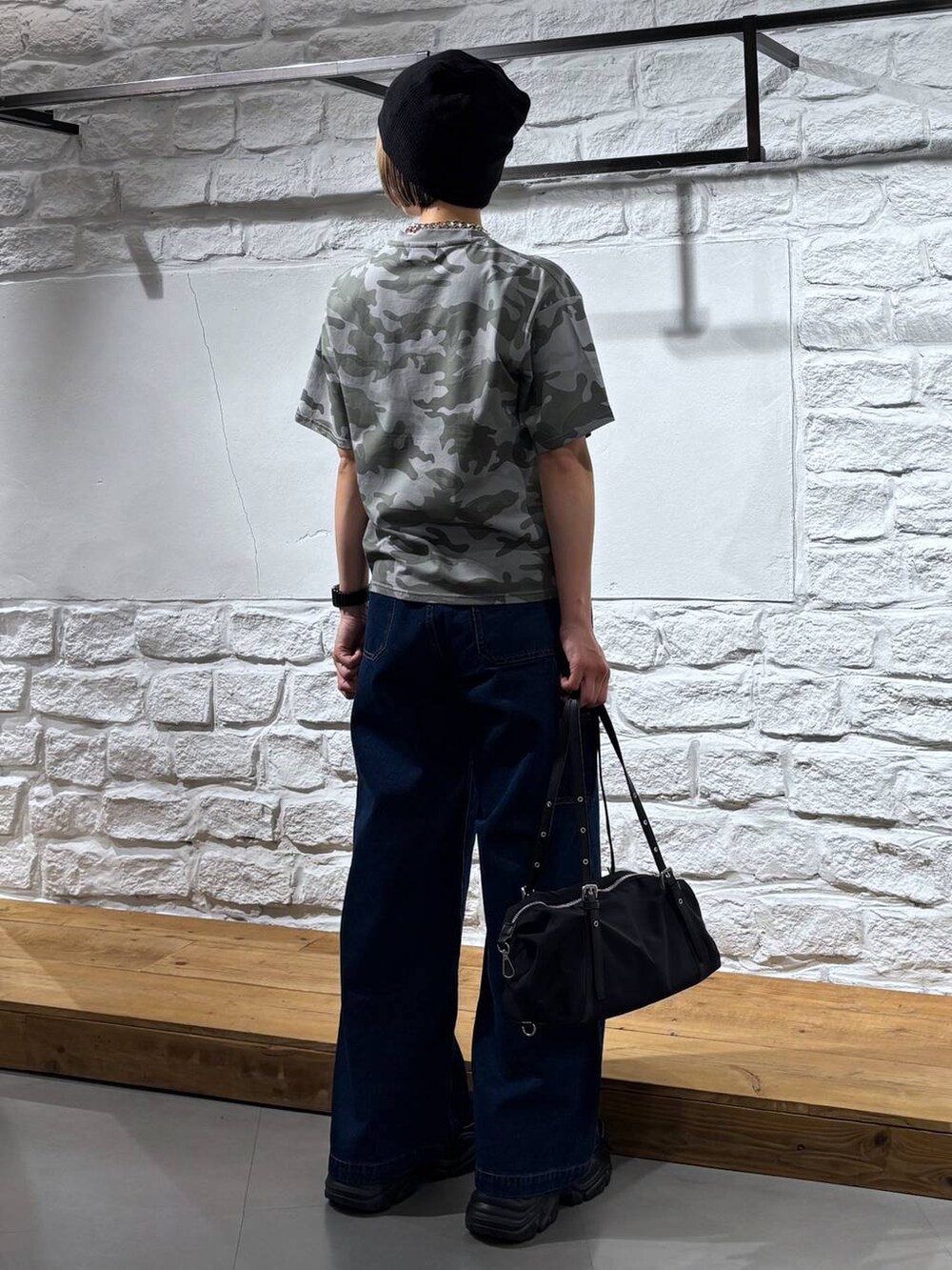 ブラック系のスニーカー、ブルー系のデニムパンツ、その他のTシャツ/カットソーを着用したレディースの春コーディネートの5枚目の写真