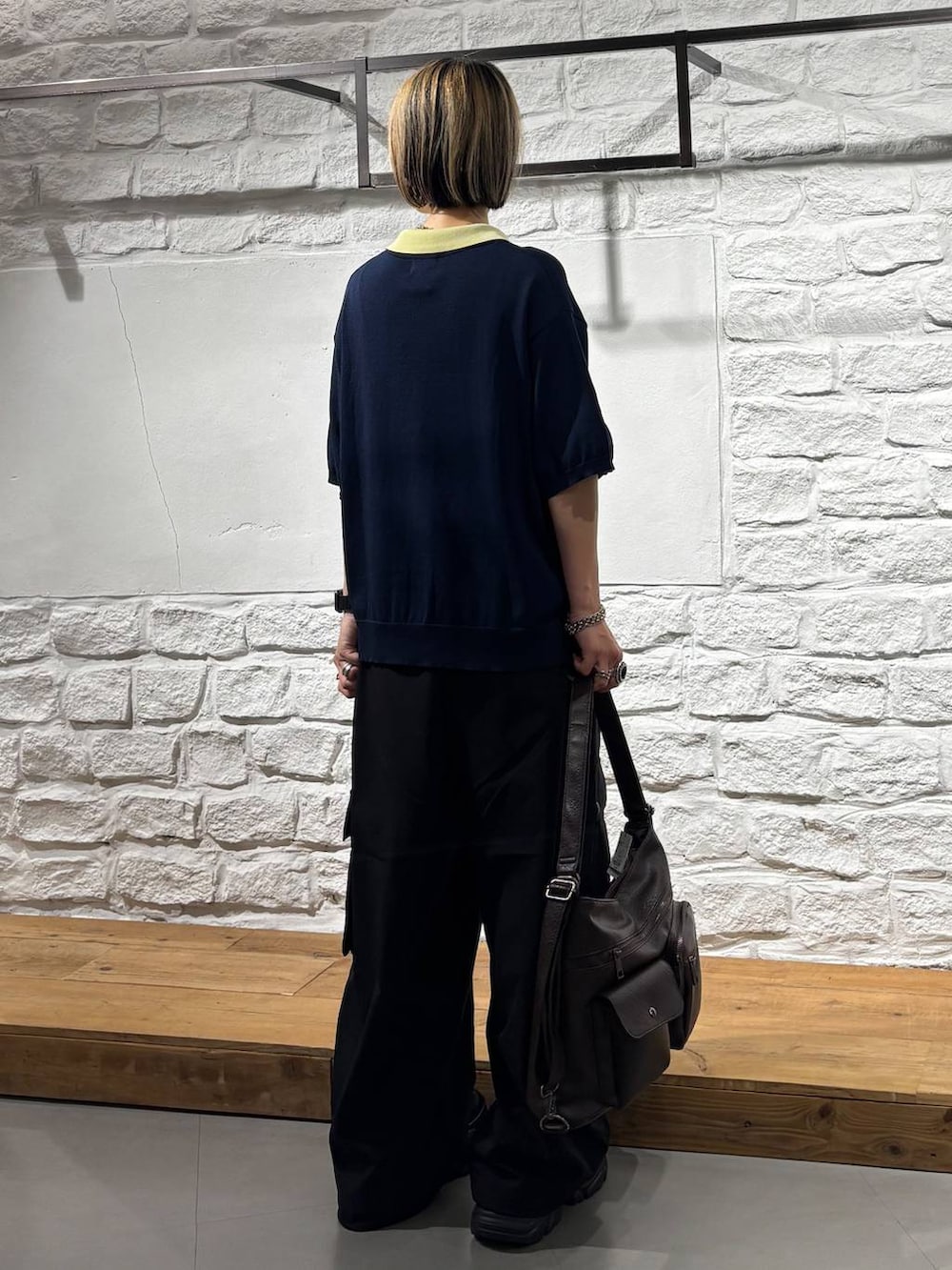 ブルー系のポロシャツ、ブラック系のカーゴパンツ、ブラック系のスニーカーを着用したレディースの夏コーディネートの6枚目の写真