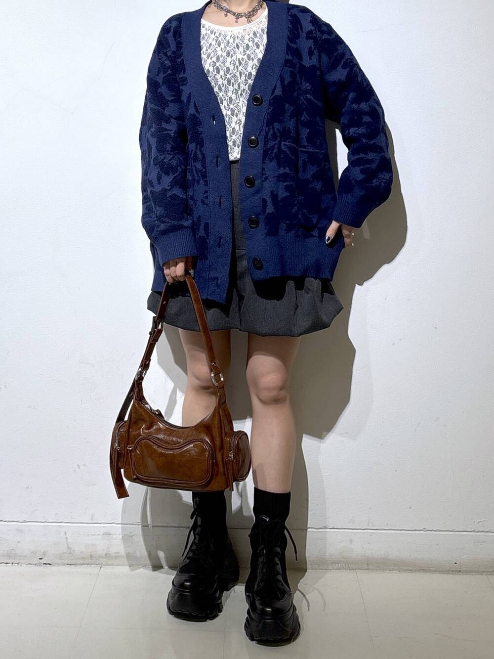 ブラック系のブーツ、ホワイト系のTシャツ/カットソー、ブラウン系のショルダーバッグを着用したレディースの秋コーディネートの2枚目の写真