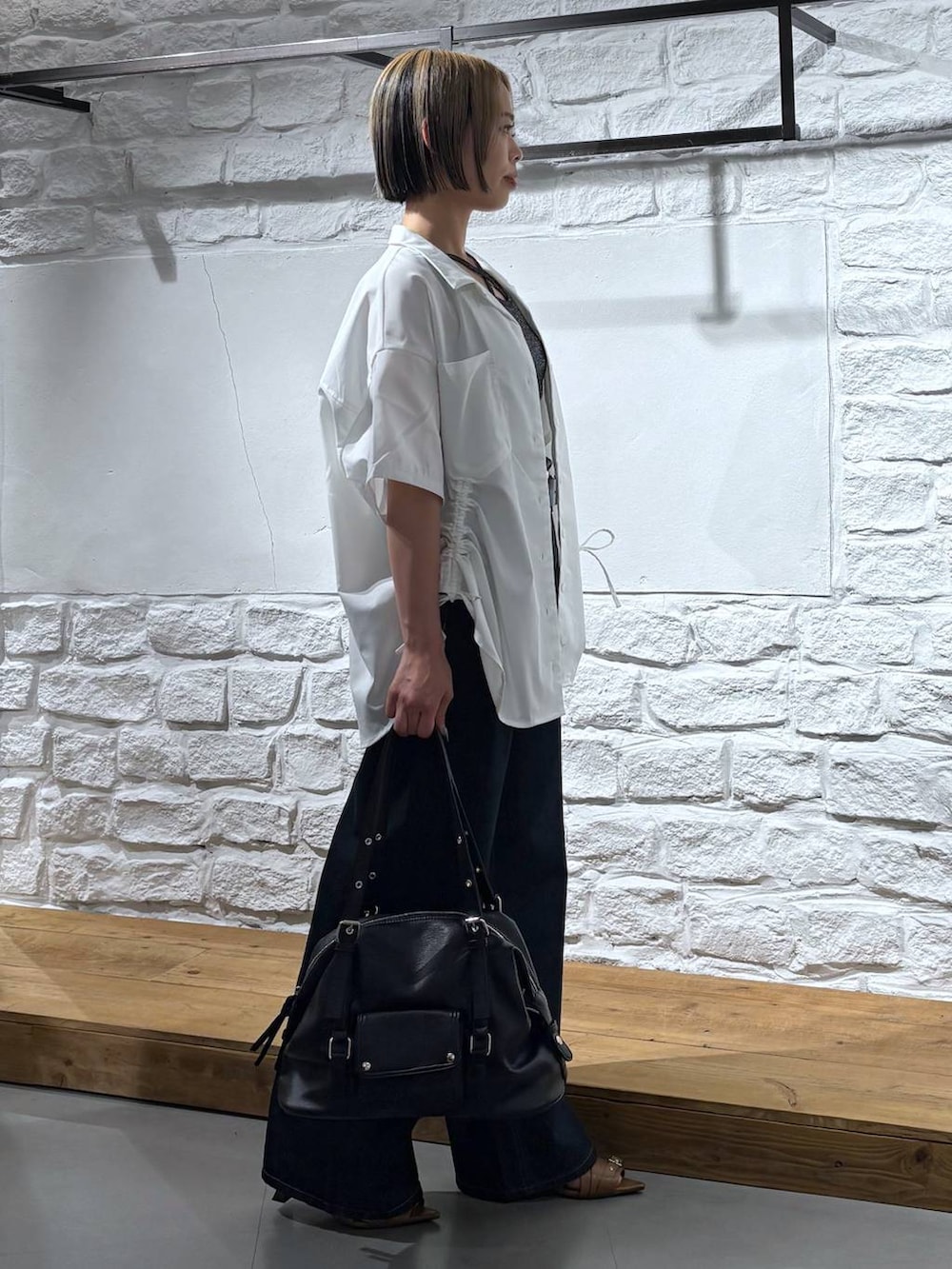 ブルー系のデニムパンツ、イエロー系のサンダル、ホワイト系のシャツ/ブラウスを着用したレディースの春コーディネートの4枚目の写真