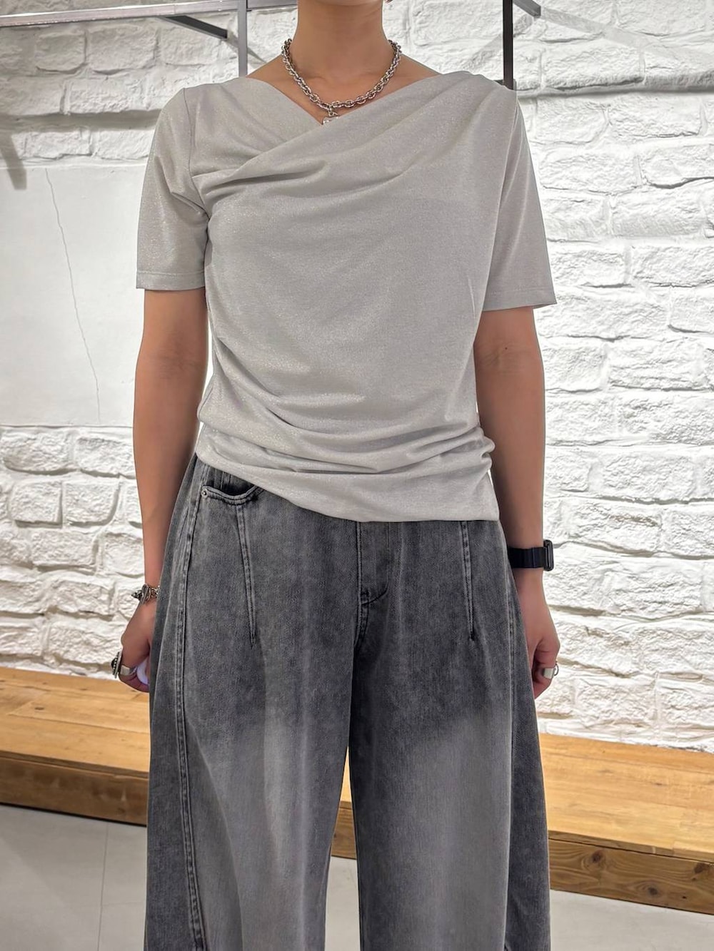 ブラック系のデニムパンツ、グレー系のサンダル、ベージュ系のTシャツ/カットソーを着用したレディースの夏コーディネートの4枚目の写真