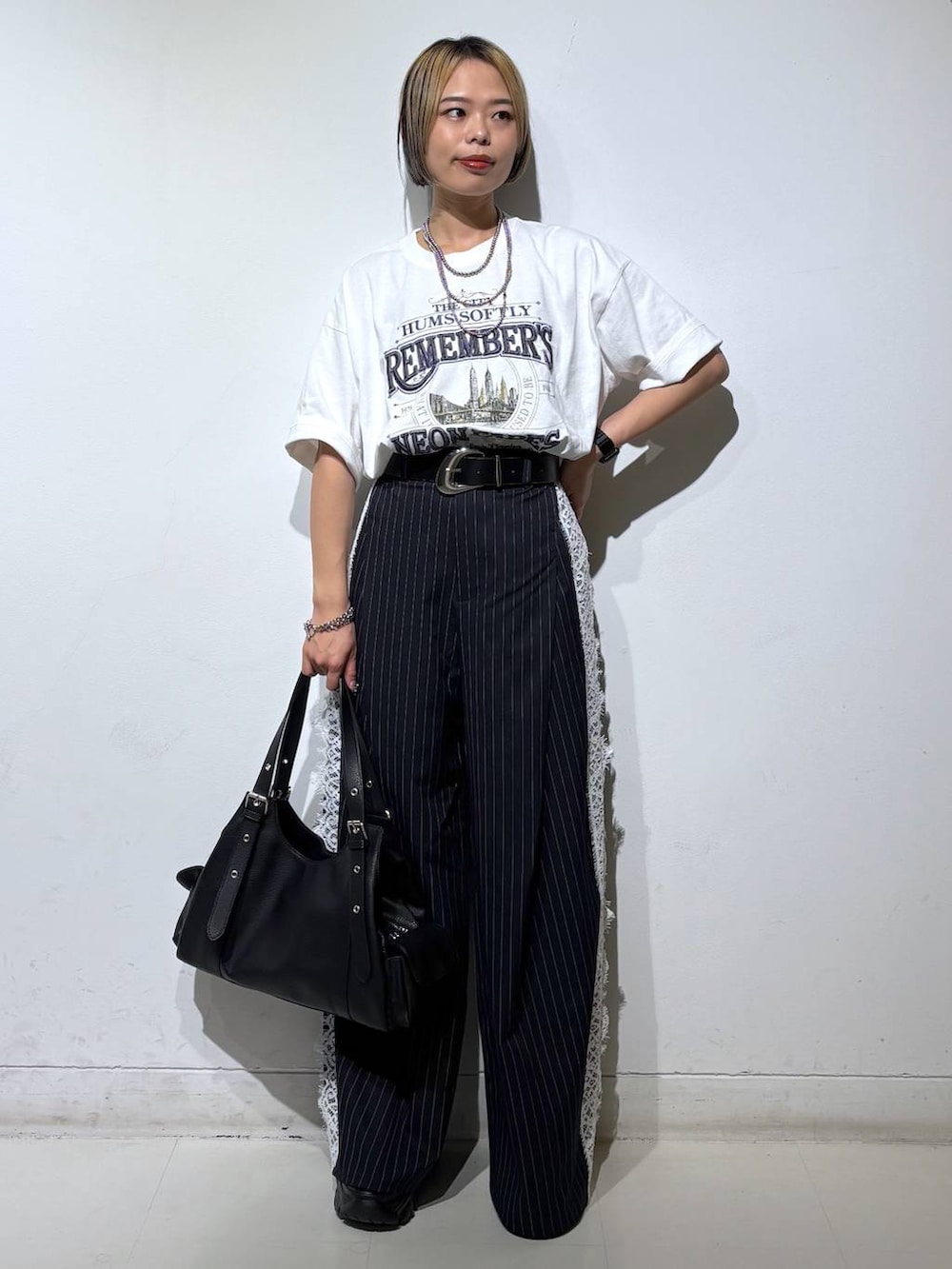 ブラック系のサンダル、ホワイト系のTシャツ/カットソー、ブルー系のスラックスを着用したレディースの夏コーディネートの2枚目の写真