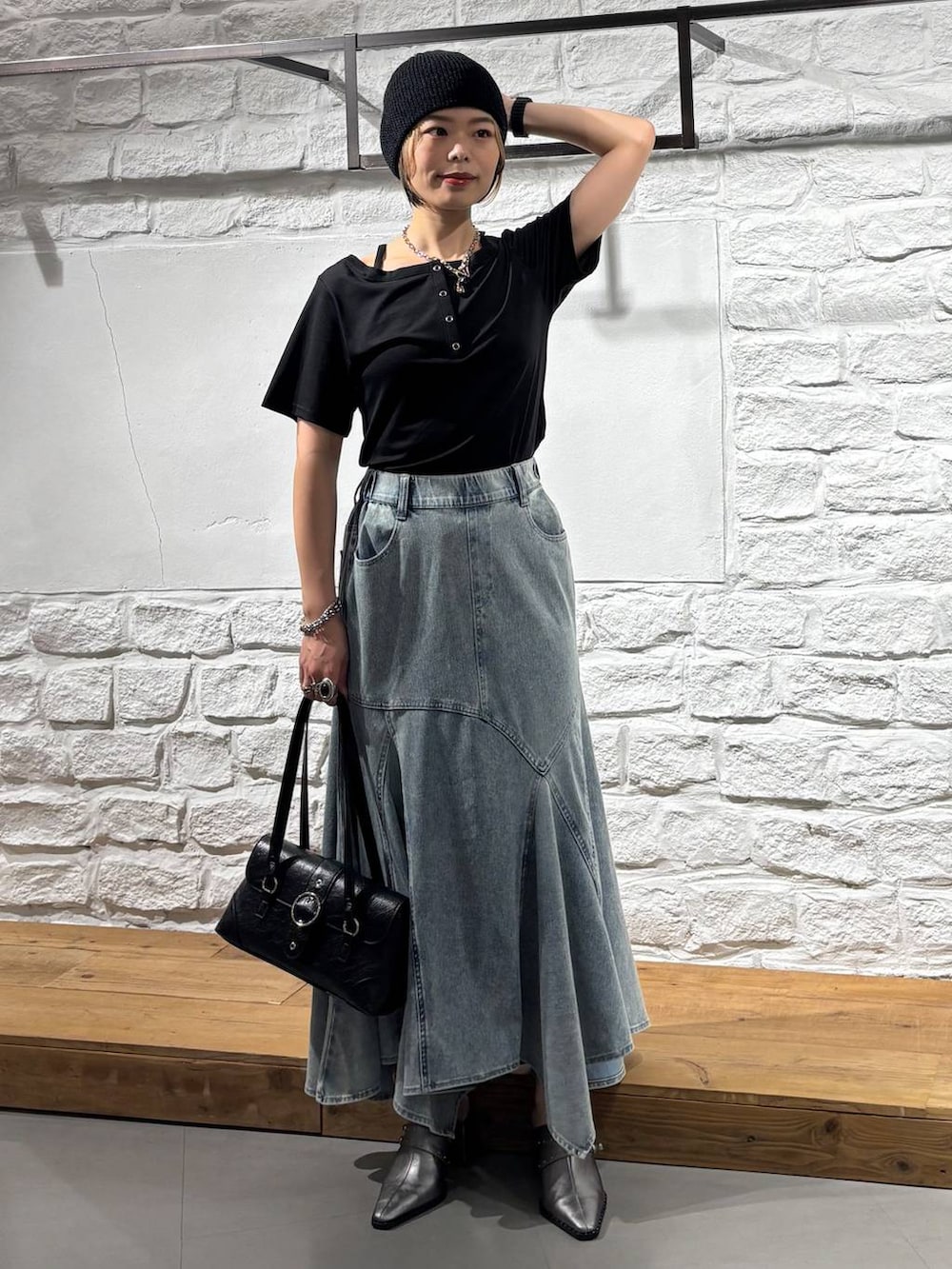 ブラック系のTシャツ/カットソー、ブルー系のデニムスカート、ブラック系のショルダーバッグを着用したレディースの夏コーディネートの2枚目の写真