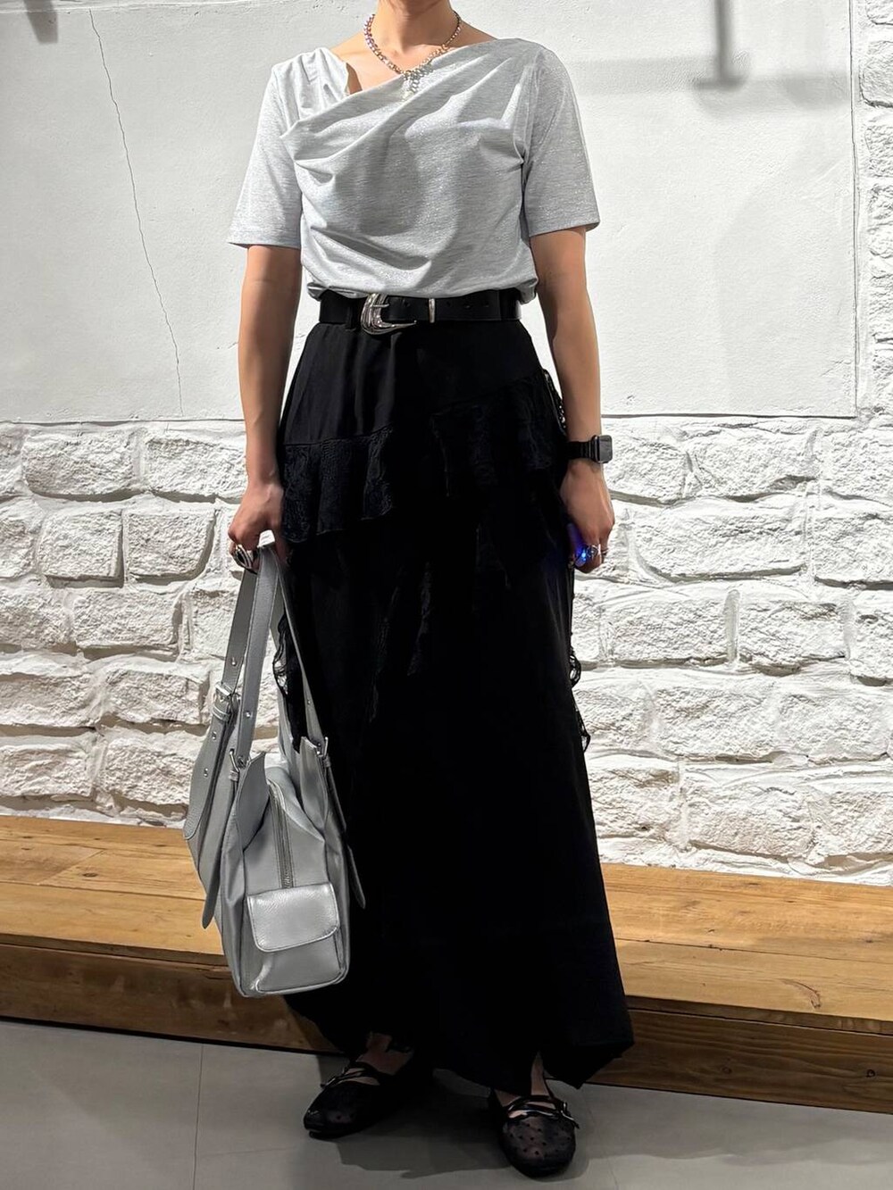 ブラック系のパンプス、シルバー系のハンドバッグ、ブラック系のスカートを着用したレディースの春コーディネートの3枚目の写真