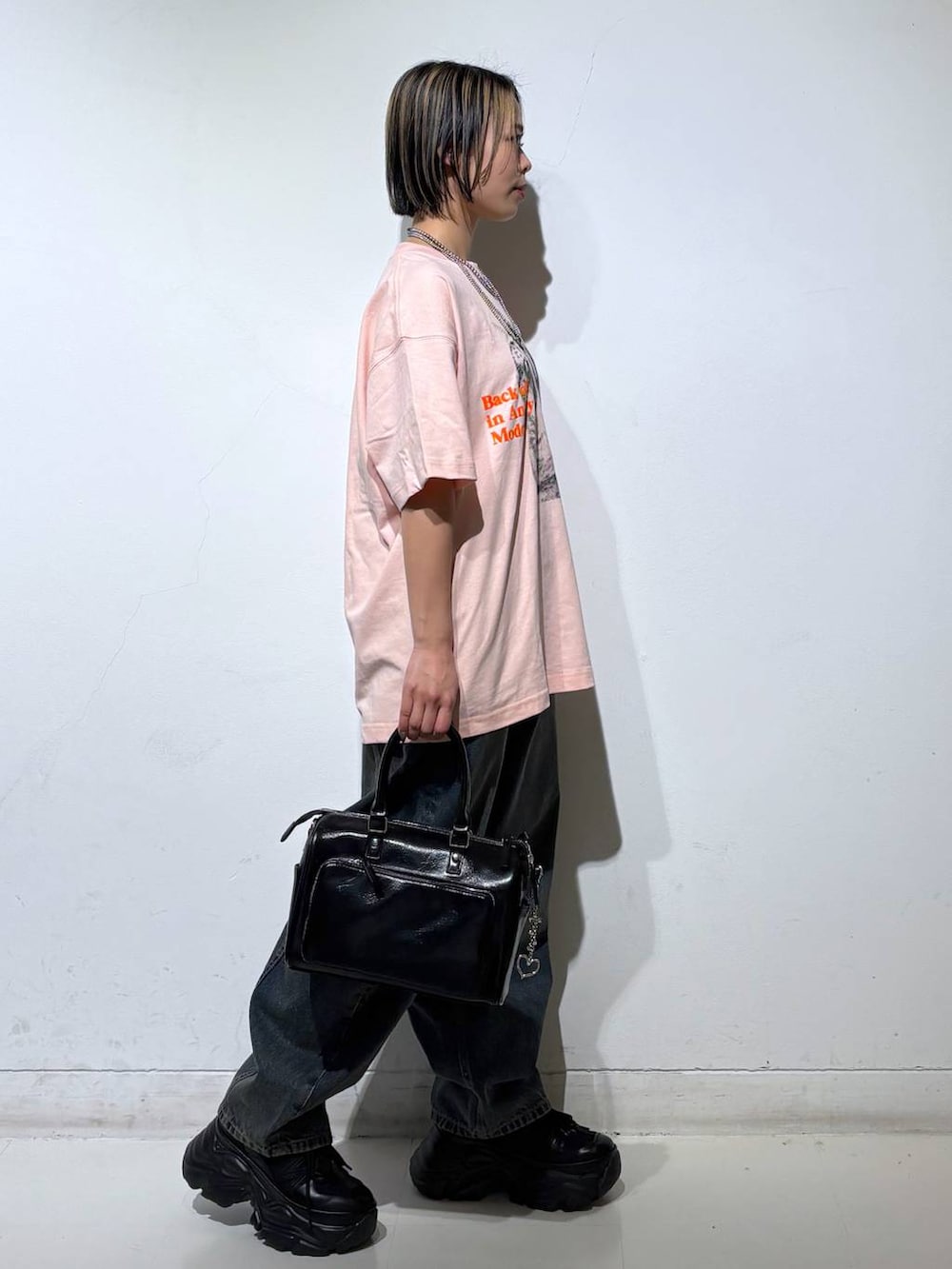 ブラック系のスニーカー、ブルー系のデニムパンツ、ブラック系のショルダーバッグを着用したレディースの春コーディネートの4枚目の写真