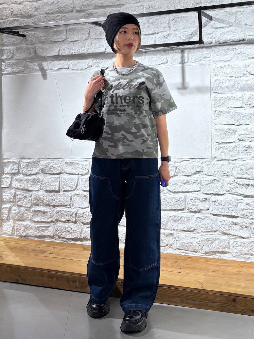 ブラック系のスニーカー、ブルー系のデニムパンツ、その他のTシャツ/カットソーを着用したレディースの春コーディネートの2枚目の写真
