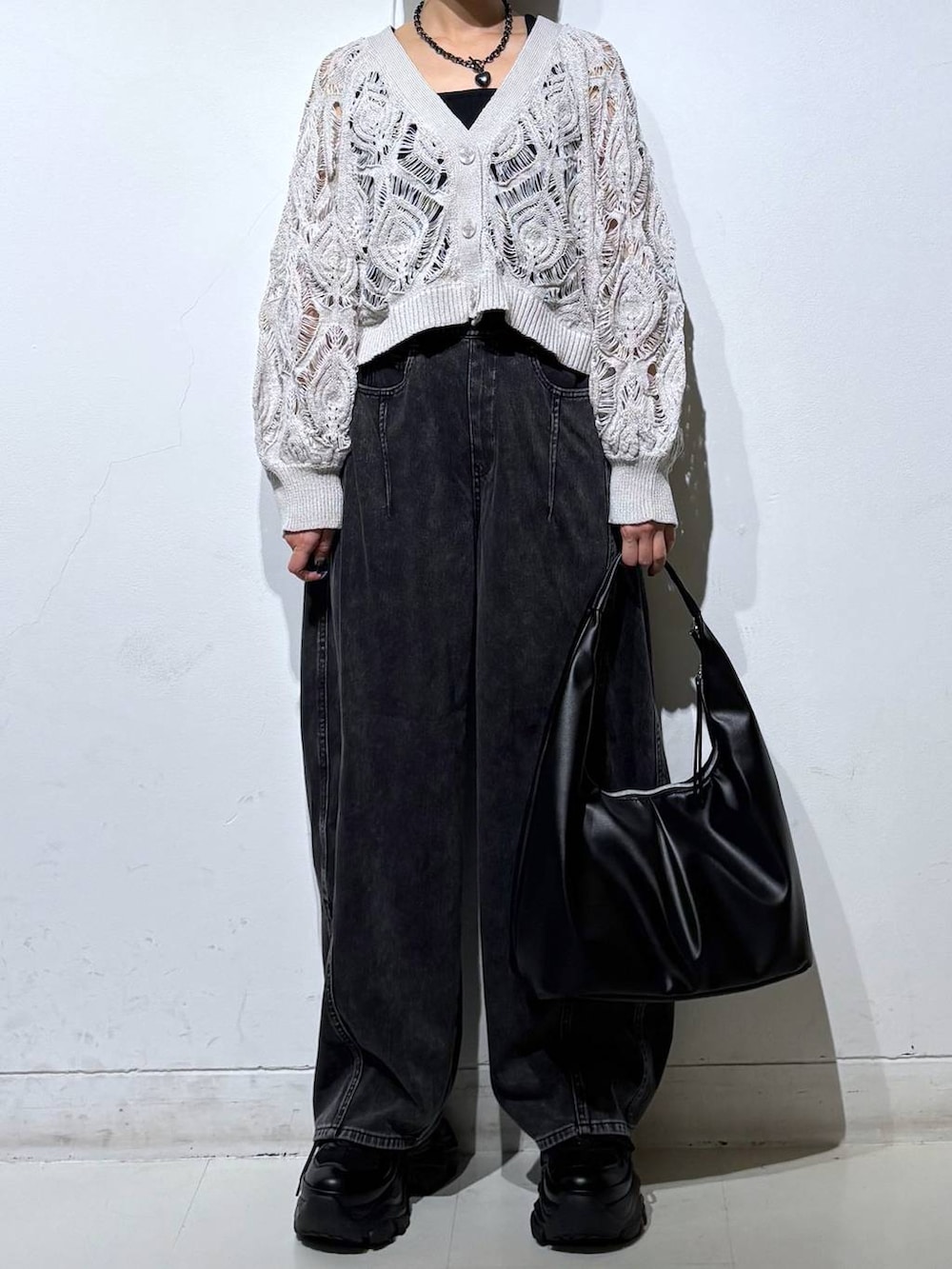 ブラック系のスニーカー、ベージュ系のカーディガン/ボレロ、ブラック系のデニムパンツを着用したレディースの春コーディネートの3枚目の写真