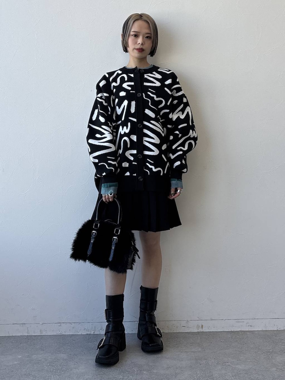 ブラック系のブーツ、ブラック系のボストンバッグ、ブラック系のその他パンツを着用したレディースの冬コーディネートの4枚目の写真