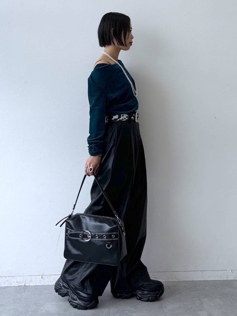 ブラック系のスニーカー、ブラック系のスラックス、ブルー系のTシャツ/カットソーを着用したレディースの秋コーディネートの5枚目の写真