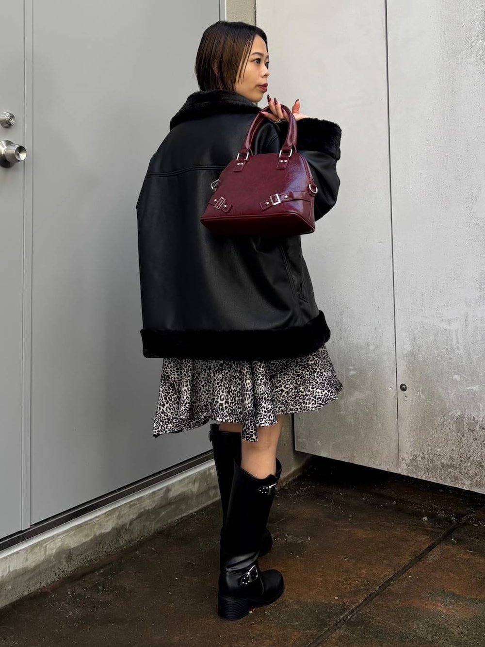 ブラック系のシャツ/ブラウス、ブラック系のブーツ、レッド系のショルダーバッグを着用したレディースの秋コーディネートの7枚目の写真