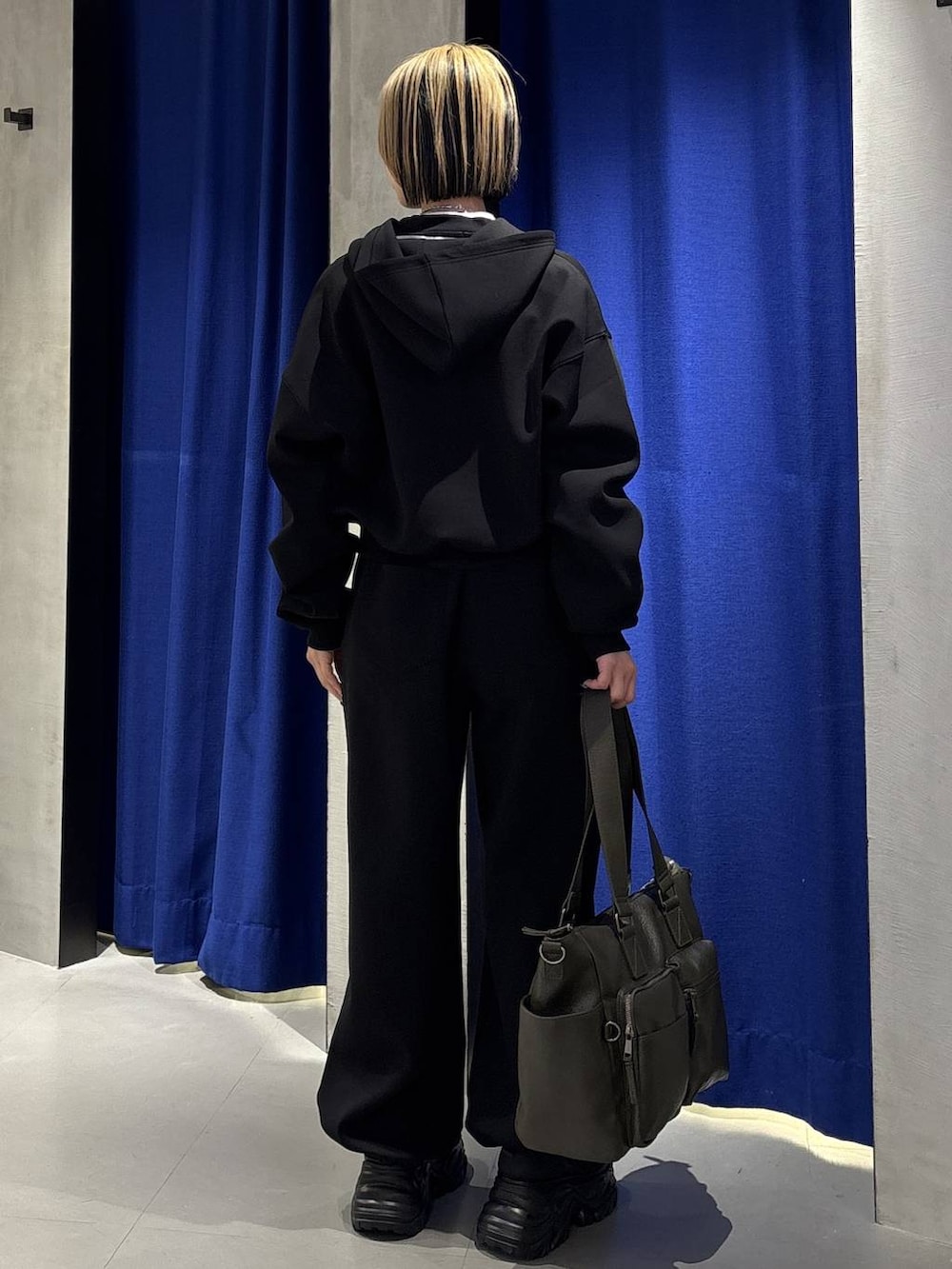 ブラック系のスニーカー、グリーン系のボストンバッグ、ブラック系のパーカーを着用したレディースの冬コーディネートの5枚目の写真