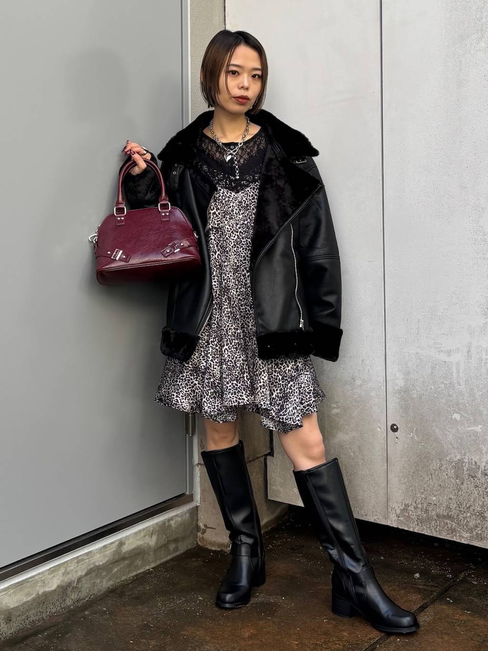 ブラック系のシャツ/ブラウス、ブラック系のブーツ、レッド系のショルダーバッグを着用したレディースの秋コーディネートの5枚目の写真