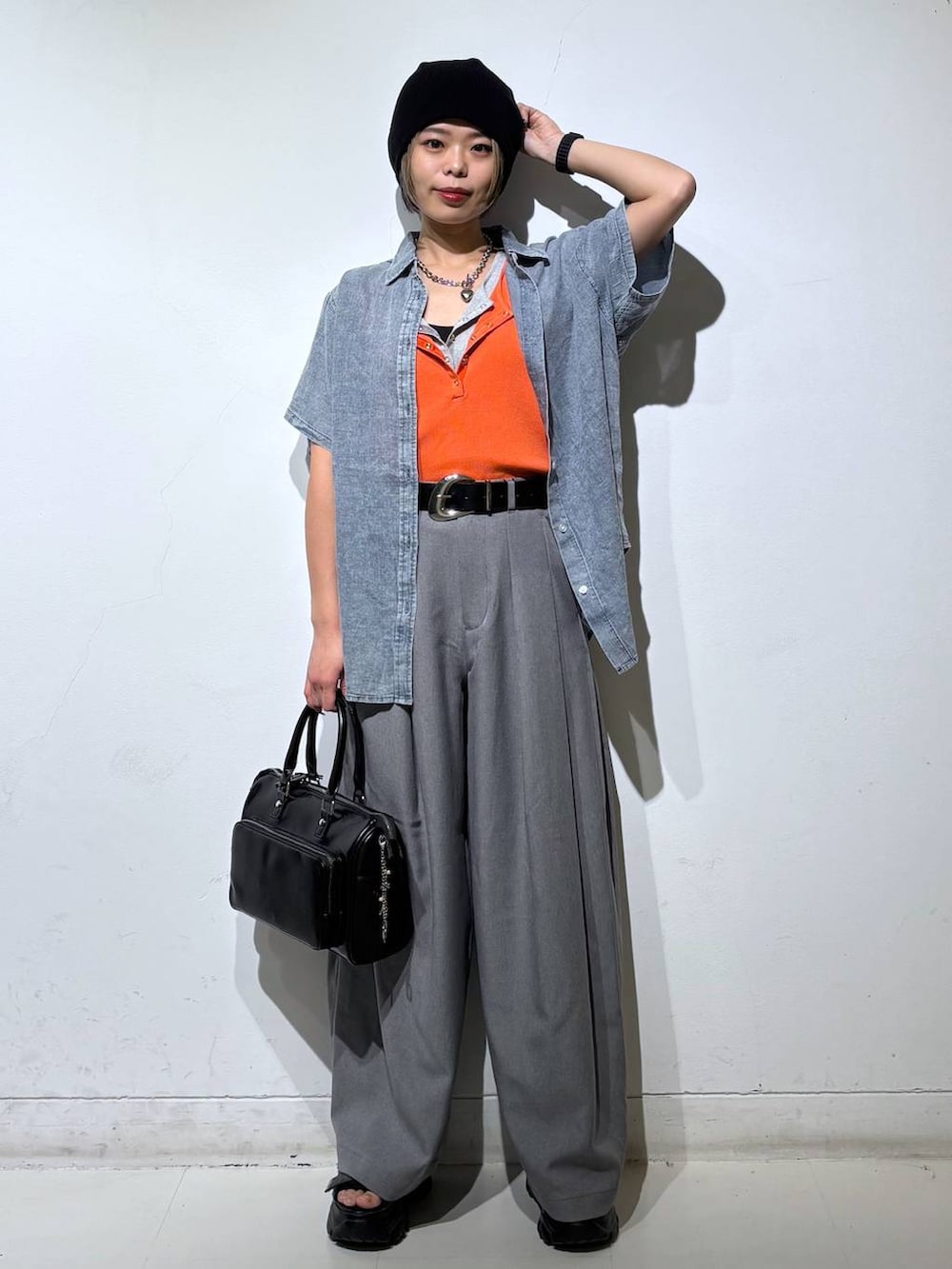 ブラック系のショルダーバッグ、グレー系のスラックス、グレー系のタンクトップを着用したレディースの春コーディネートの2枚目の写真