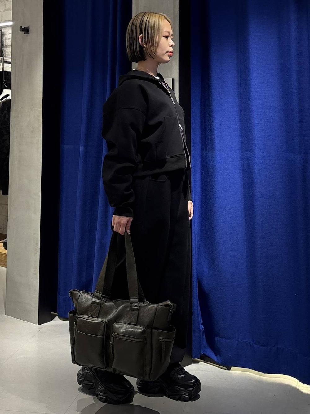 ブラック系のスニーカー、グリーン系のボストンバッグ、ブラック系のパーカーを着用したレディースの冬コーディネートの4枚目の写真