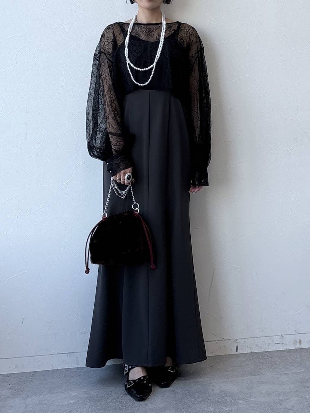 ブラック系のパンプス、レッド系のハンドバッグ、グレー系のワンピースを着用したレディースの冬コーディネートの2枚目の写真