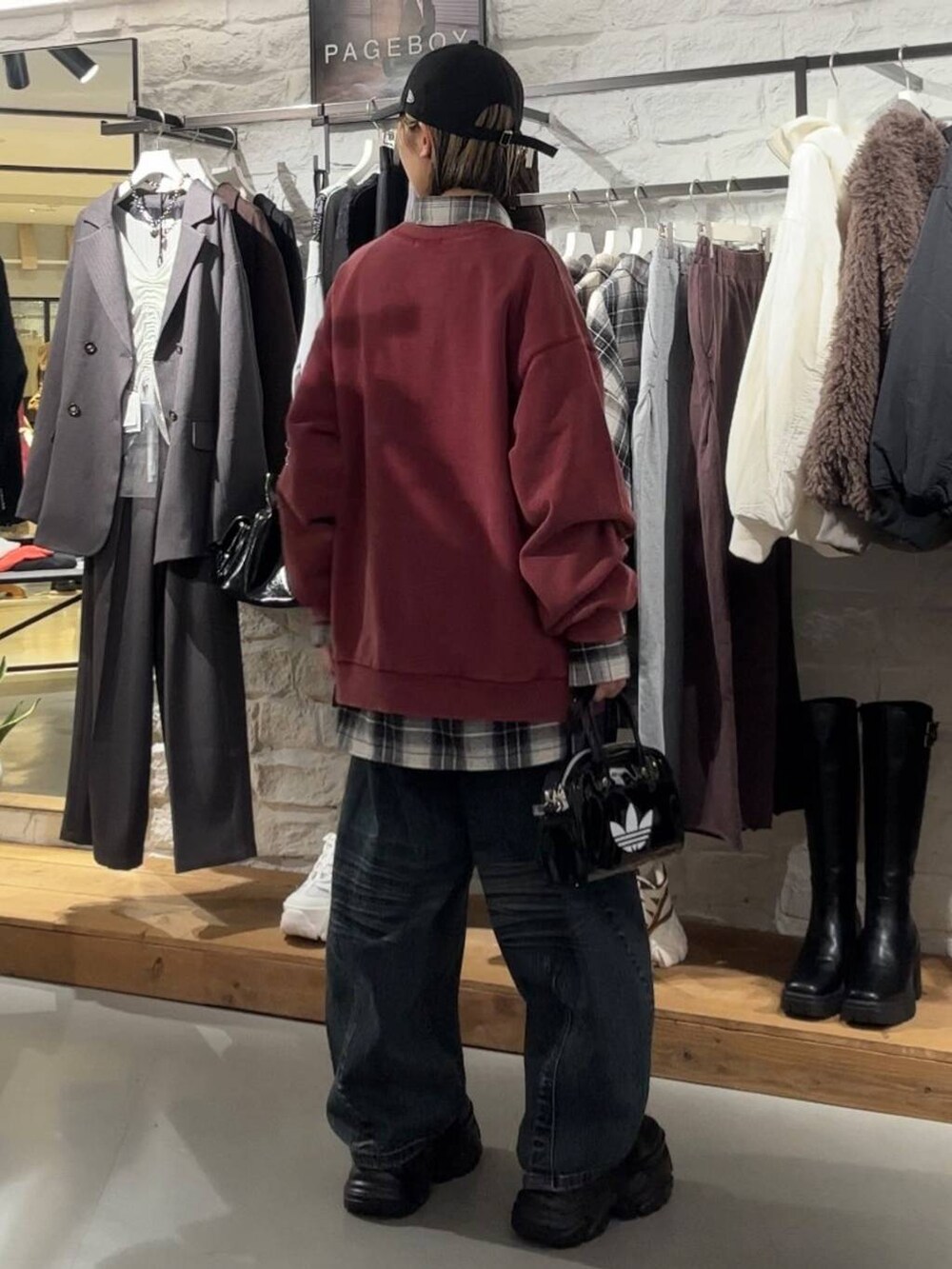 ブラック系のブーツ、レッド系のスウェット、ブラック系のTシャツ/カットソーを着用したレディースの秋コーディネートの5枚目の写真