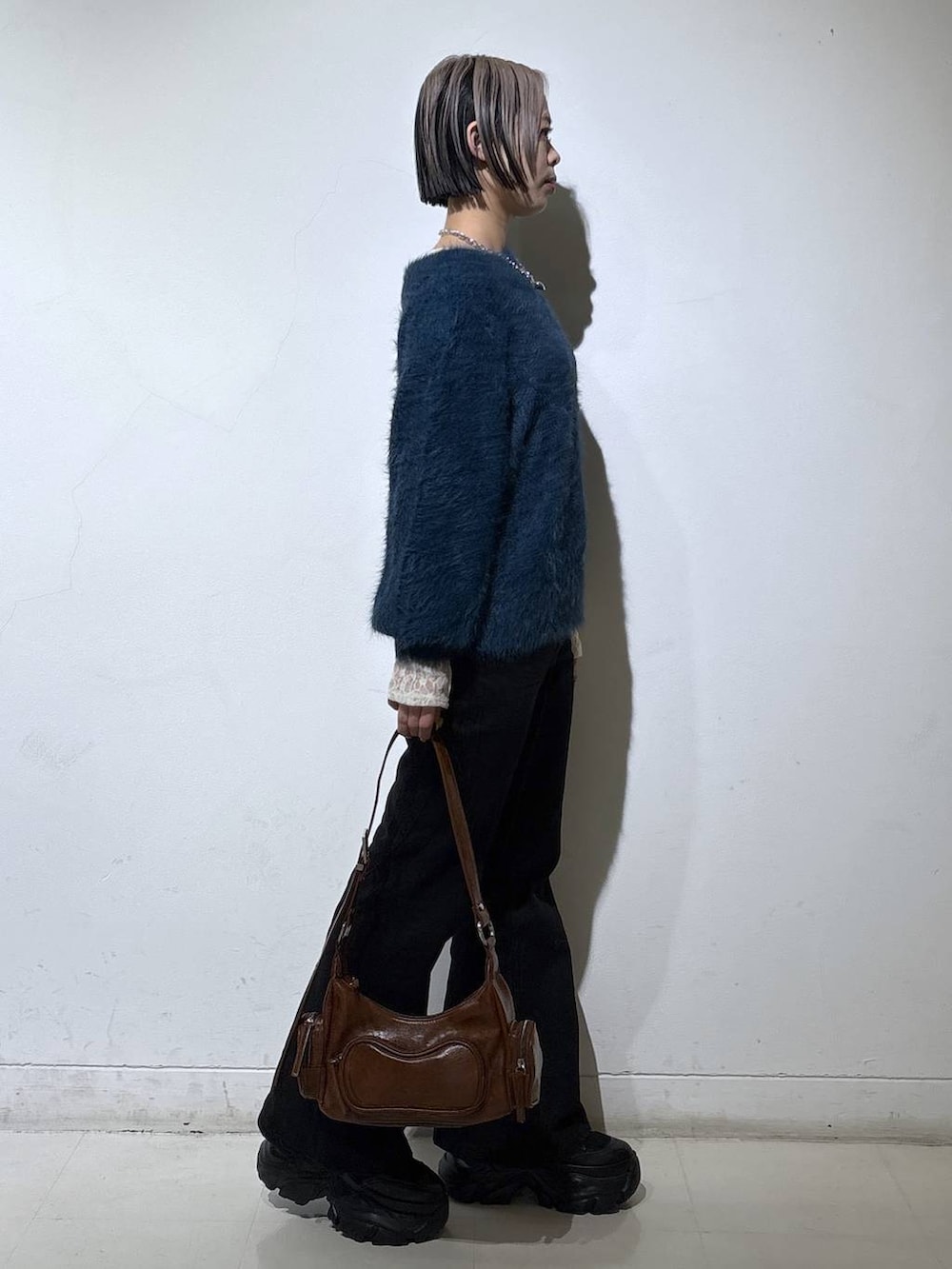 ブラック系のブーツ、ブラック系のデニムパンツ、ホワイト系のTシャツ/カットソーを着用したレディースの冬コーディネートの3枚目の写真