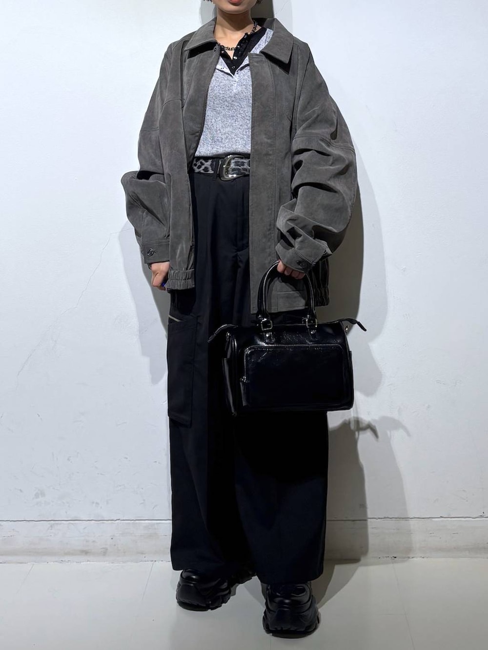 ブラック系のスニーカー、ブラック系のショルダーバッグ、グレー系のブルゾンを着用したレディースの春コーディネートの3枚目の写真