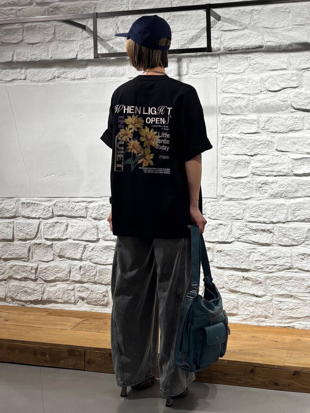 ブルー系のショルダーバッグ、ブラック系のデニムパンツ、イエロー系のサンダルを着用したレディースの春コーディネートの5枚目の写真