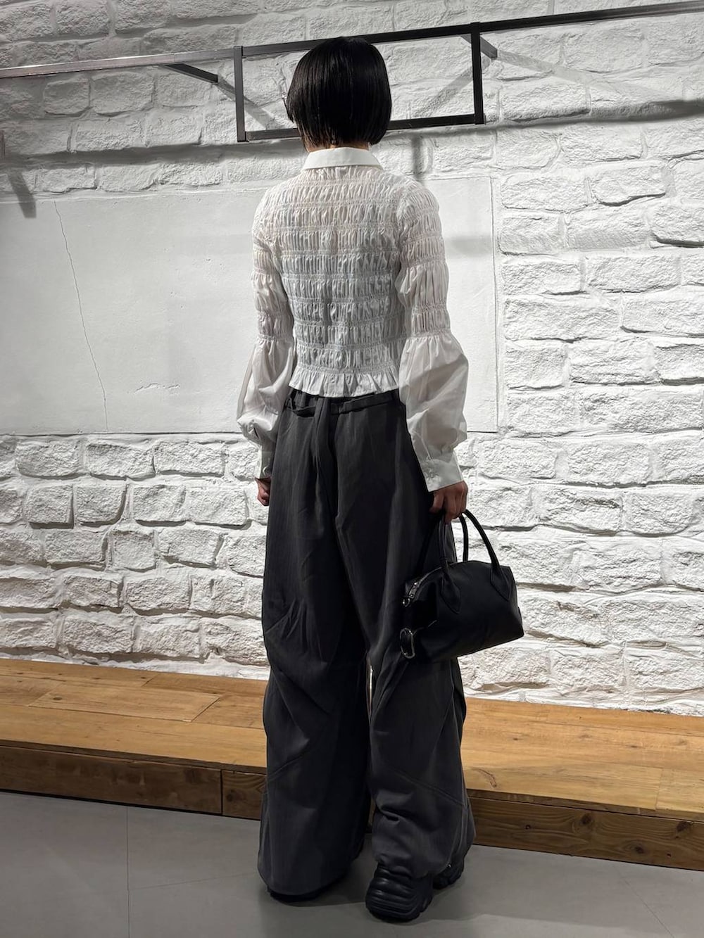 ブラック系のスニーカー、ブラック系のショルダーバッグ、ホワイト系のTシャツ/カットソーを着用したレディースの秋コーディネートの6枚目の写真