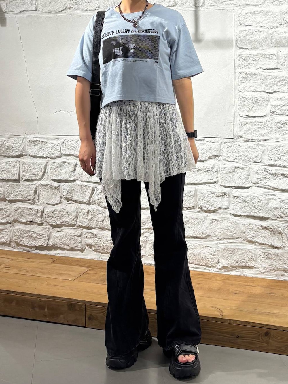 ブルー系のTシャツ/カットソー、ブラック系のデニムパンツ、ブラック系のショルダーバッグを着用したレディースの夏コーディネートの3枚目の写真
