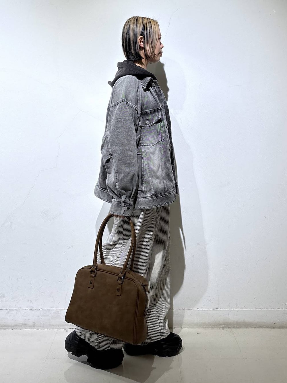 ブラック系のブーツ、ベージュ系のボストンバッグ、ブラック系のTシャツ/カットソーを着用したレディースの冬コーディネートの4枚目の写真