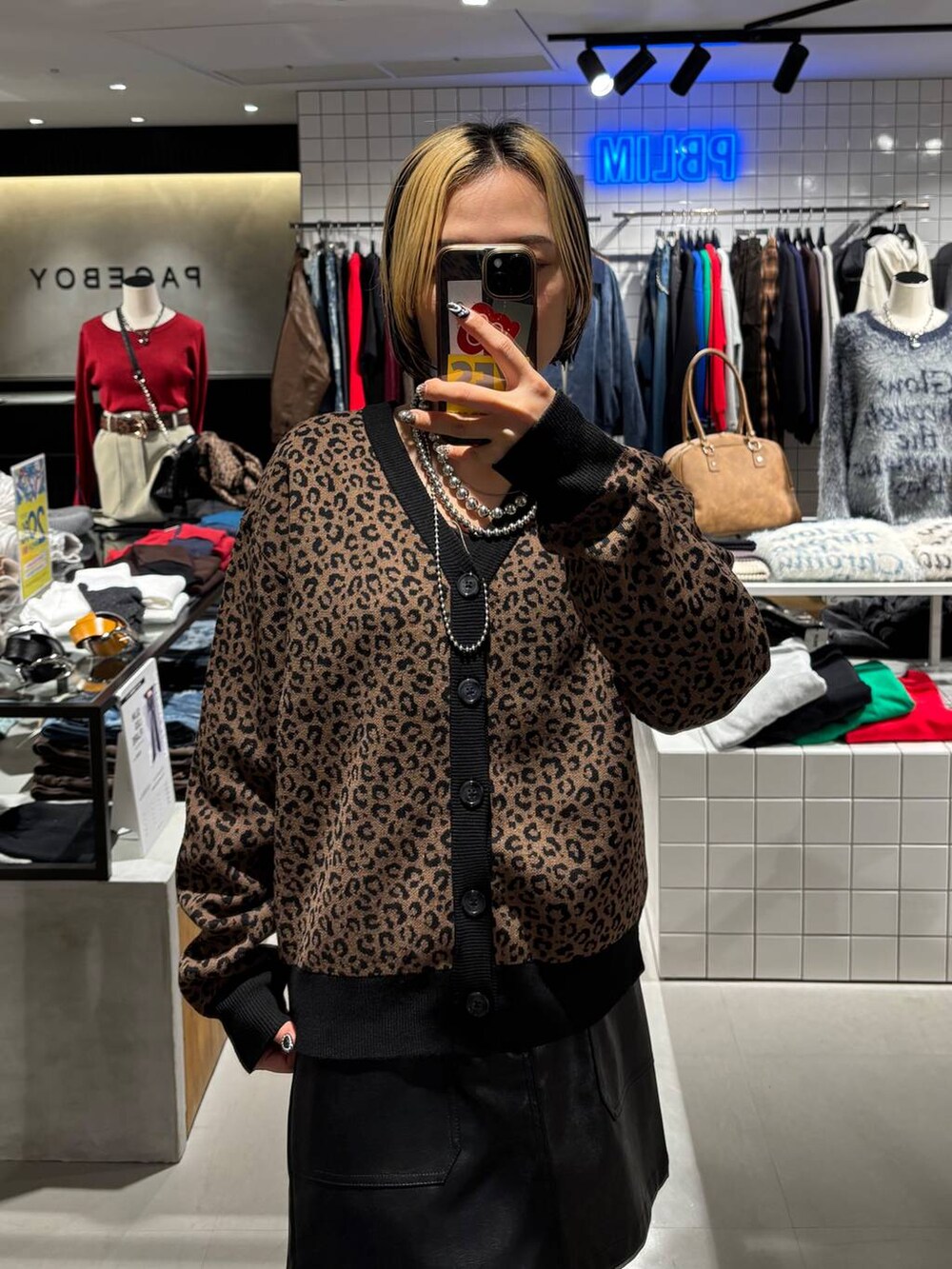 ブラック系のブーツ、ブラウン系のカーディガン/ボレロ、ブラック系のスカートを着用したレディースの秋コーディネートの4枚目の写真